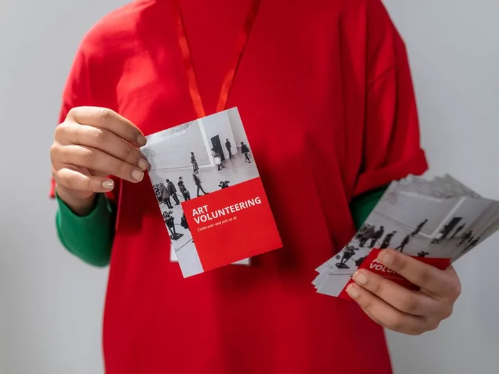 Printed flyers and postcards held in hand, ready to hand out