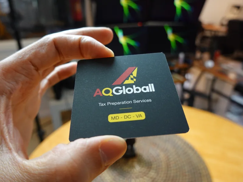 A hand holding a premium matte black business card